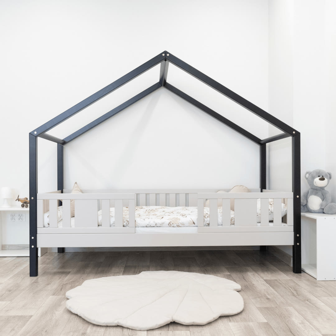 Łóżko Niko Short kaszmir w aranżacji dziecięcej z dywanem i zabawkami w tle, podkreślające jego kompaktową formę